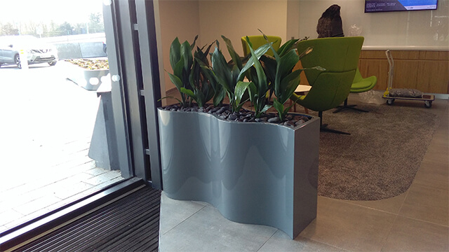 Unique plant container design by front entrance of building